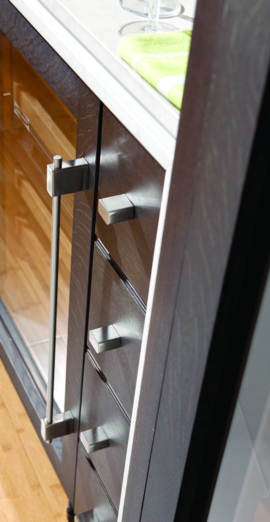 Atlas Homewares Element appliance pulls and knobs on a paneled refrigerator