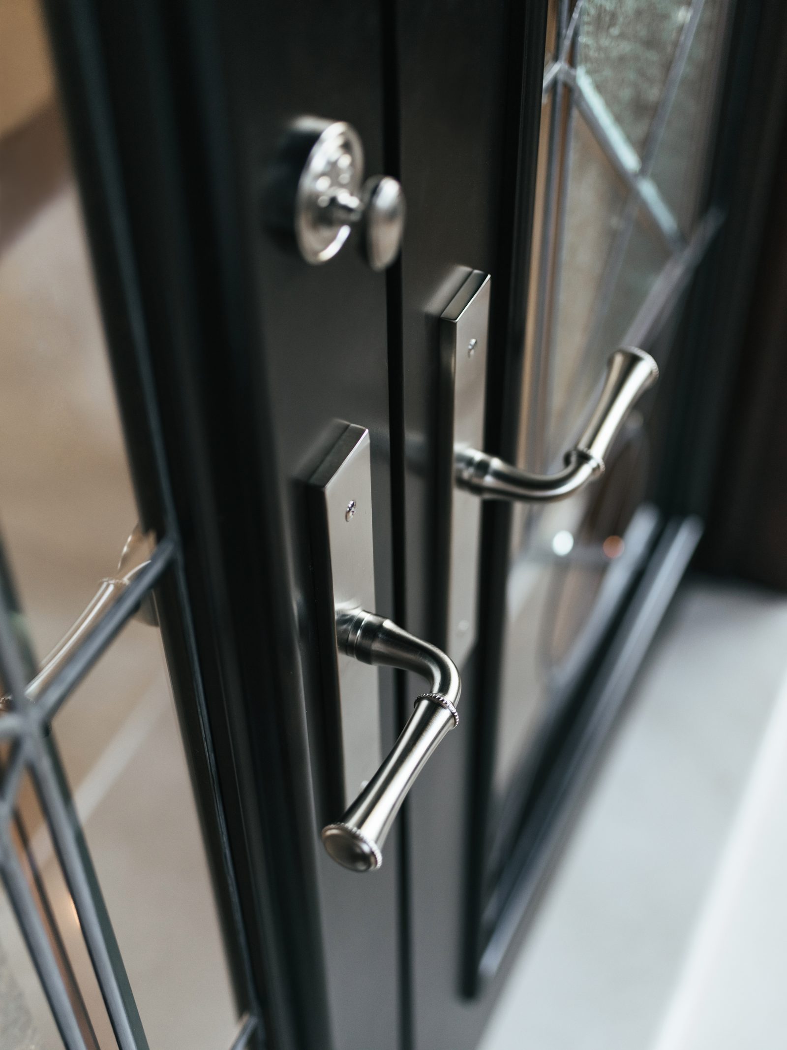 Baldwin chrome appliance door pulls on a black entry door