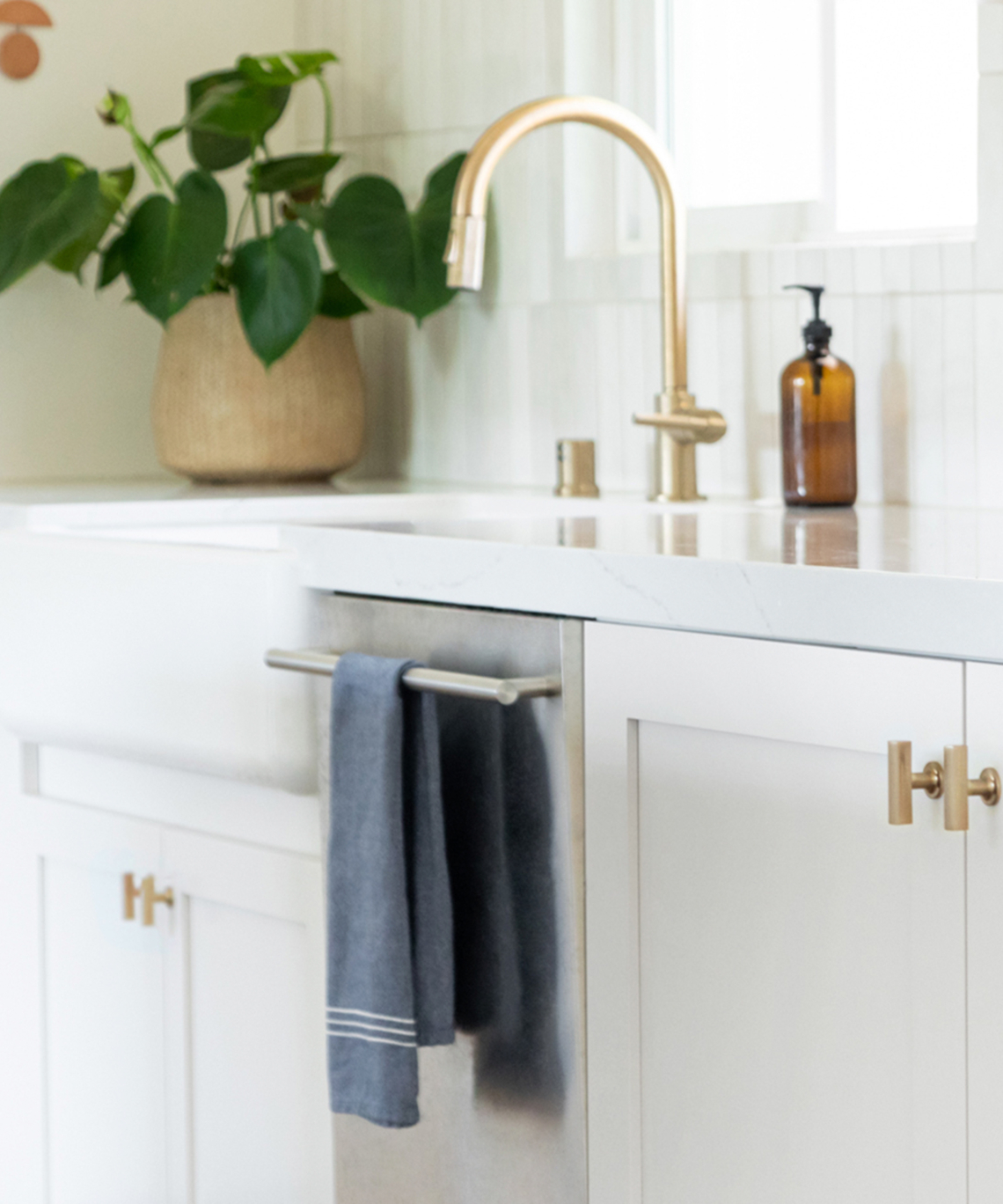 Emtek brass cabinet knobs and fixtures in a bright kitchen