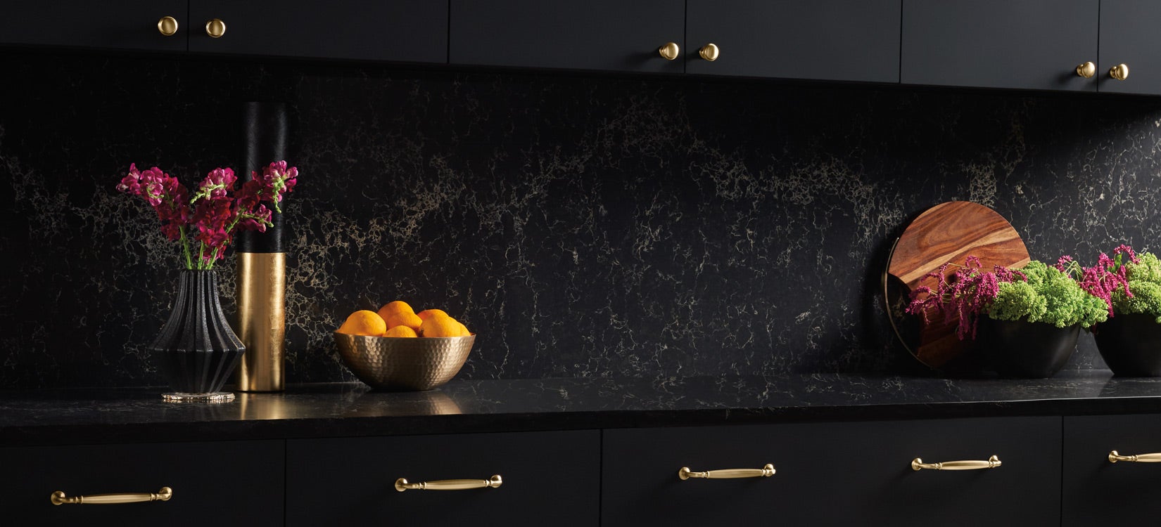Top Knobs Grace Barrow brass pulls on black cabinetry